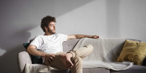 retrato-hombre-joven-afeitar-atractivo-elegante-camiseta-blanca-jeans-beige-sentado-descalzo-sofa-casa-manteniendo-ojos-cerrados-disfrutando-sol-sintiendose-relajado-despreocupado-1000×500